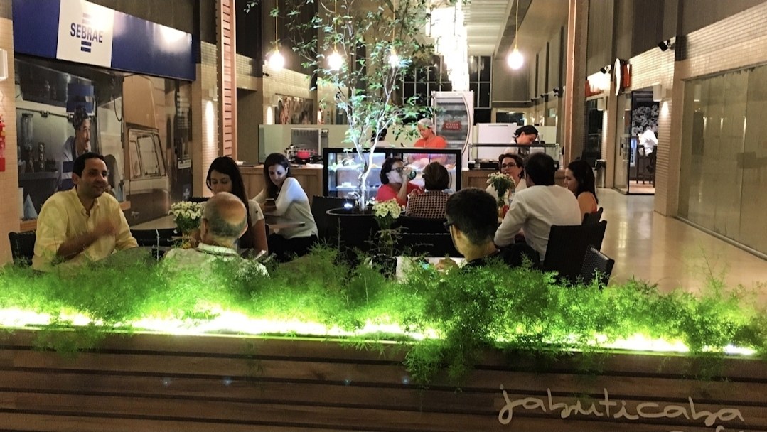 Salão do Jabuticaba Café à noite com clientes nas mesas